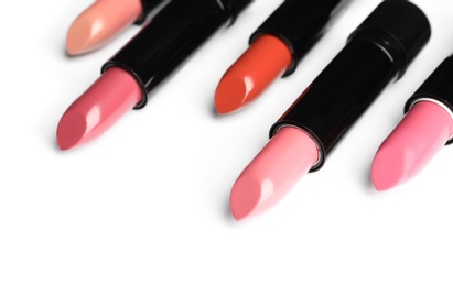 Photo of Different lipsticks on white background. Cosmetic product