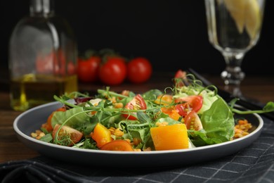 Delicious salad with lentils and vegetables served on wooden table, closeup