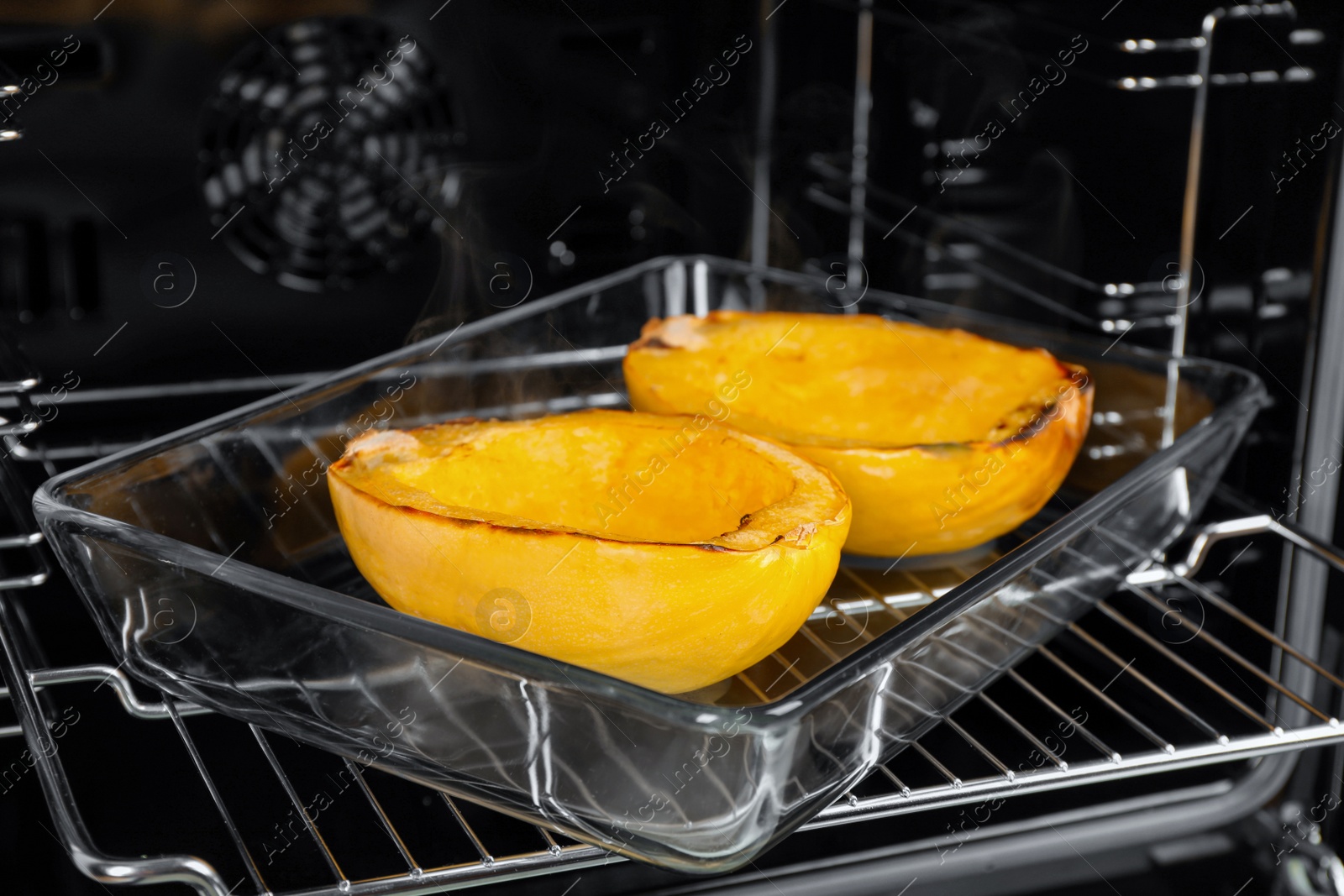 Photo of Baking dish with halves of cooked spaghetti squash in oven, closeup