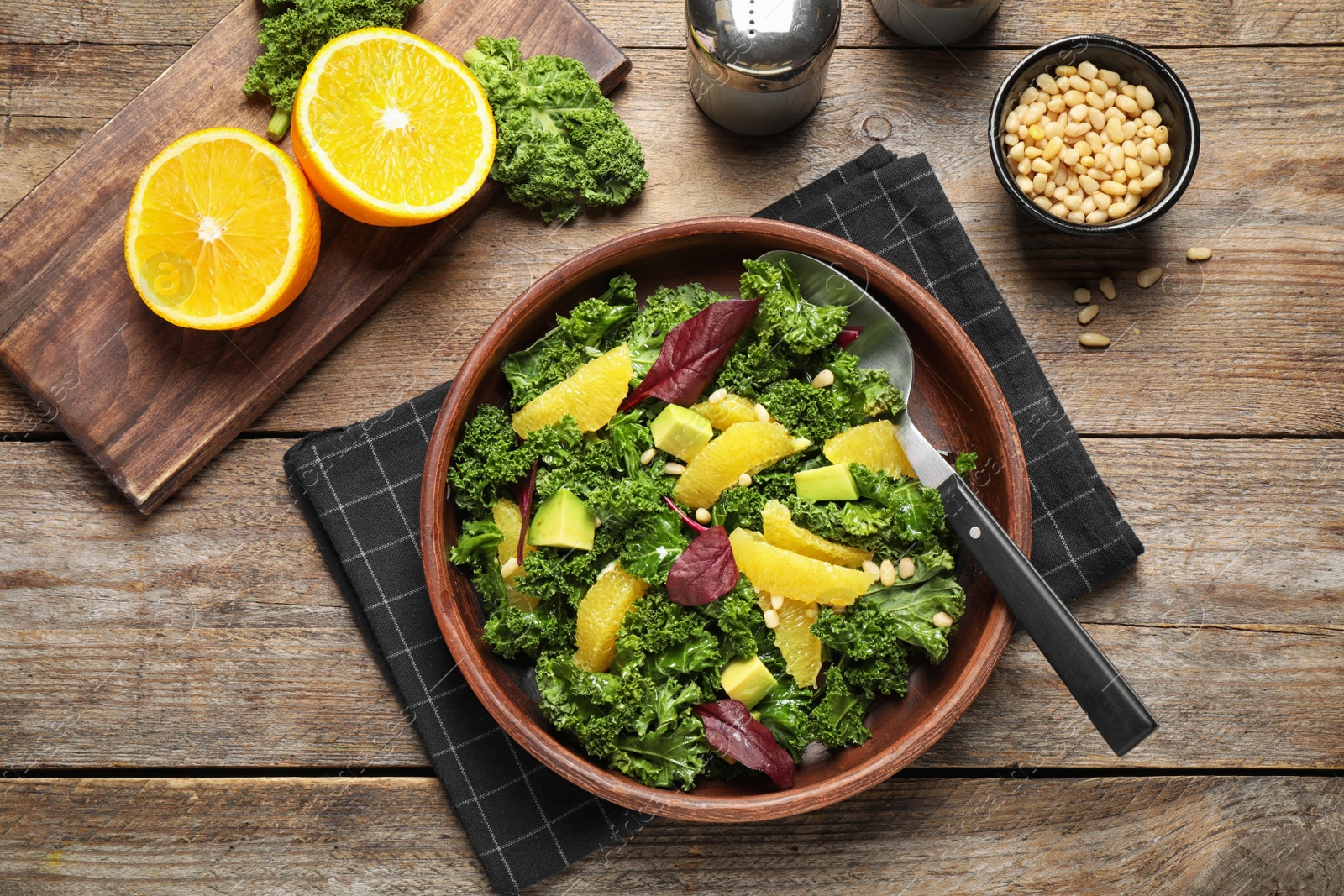 Photo of Tasty fresh kale salad on wooden table, flat lay