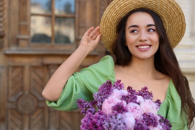 Beautiful woman with bouquet of spring flowers outdoors, space for text