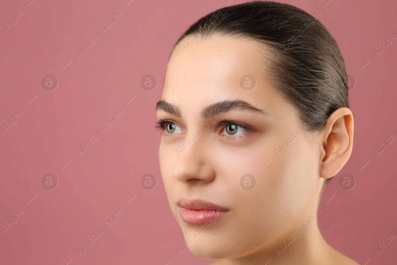 Photo of Young woman with perfect eyebrows on pink background, space for text