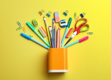 Photo of Flat lay composition with school stationery on yellow background. Back to school