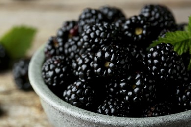 Photo of Bowl with fresh ripe blackberries on table, closeup