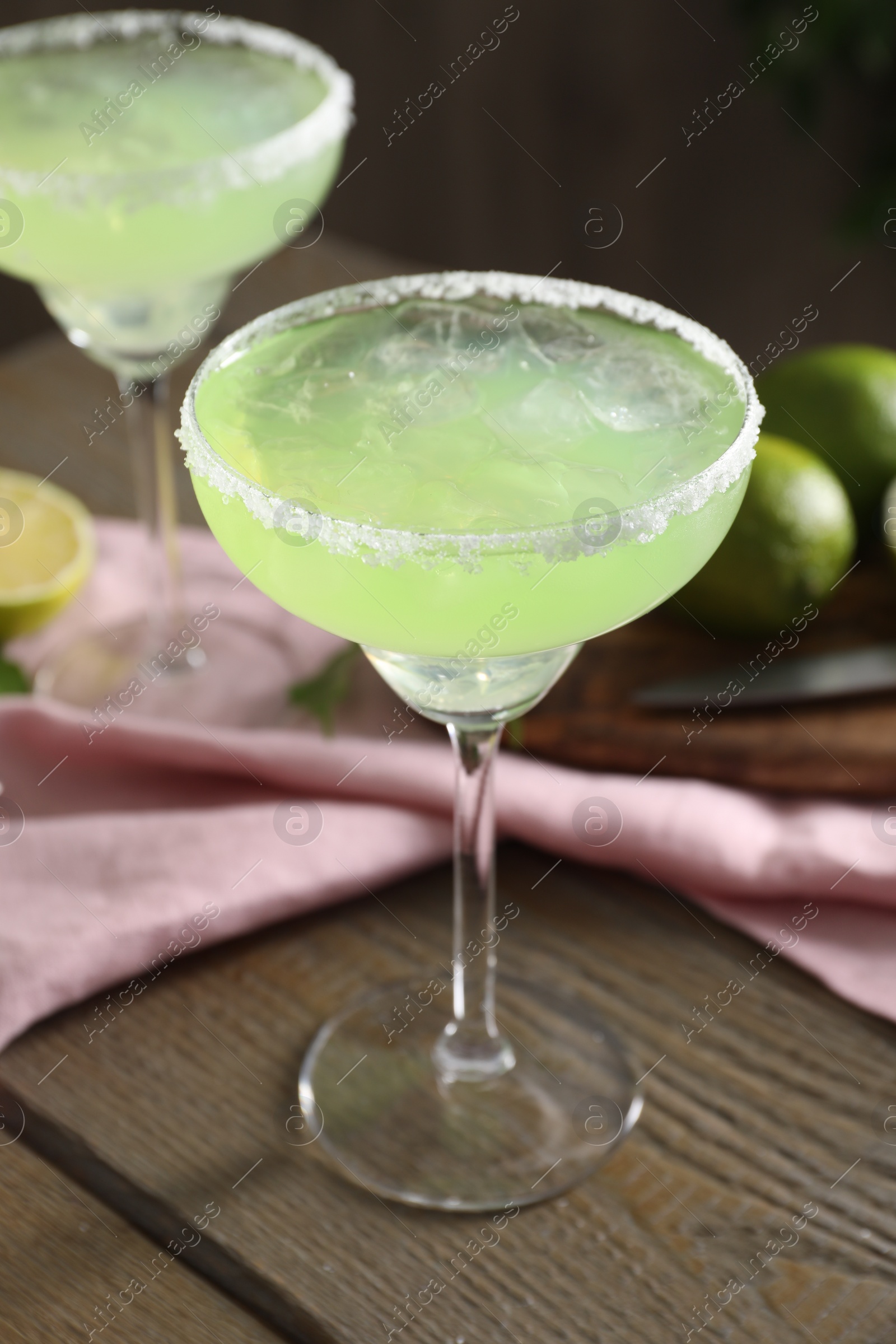 Photo of Delicious Margarita cocktail in glasses on wooden table, closeup