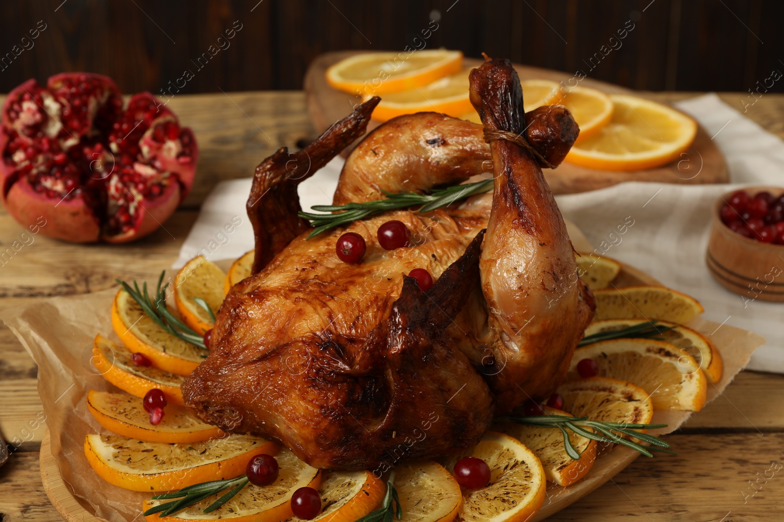 Photo of Baked chicken with orange slices on wooden table