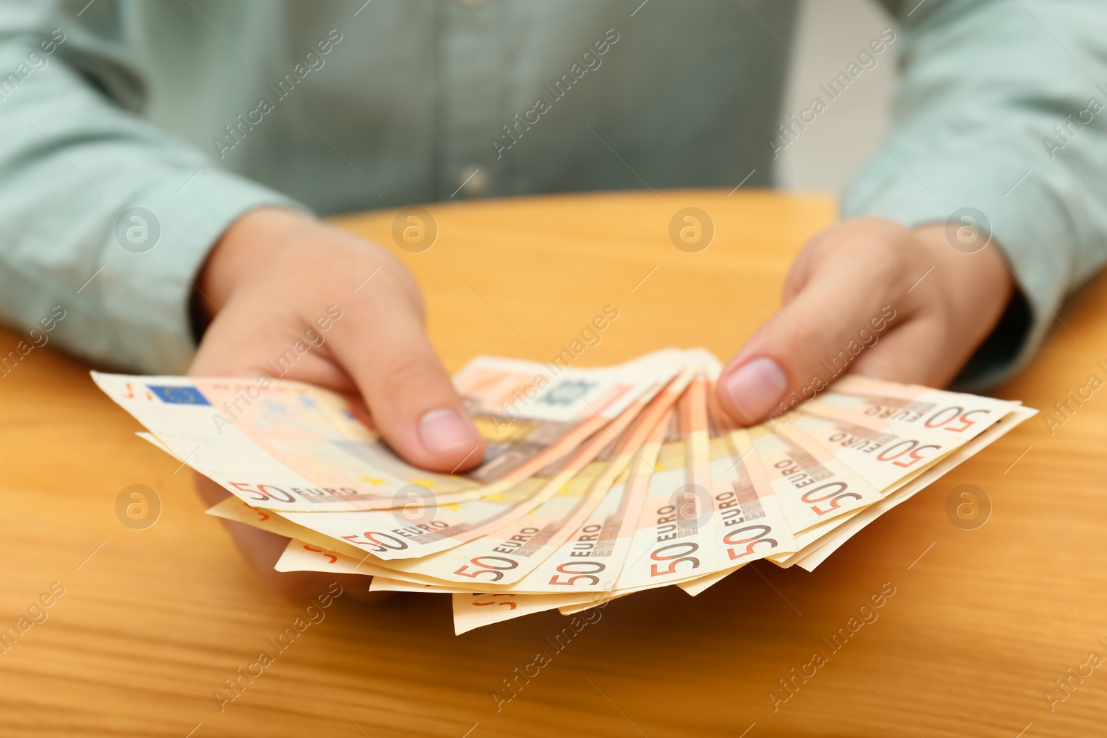 Photo of Man with Euro banknotes at table, closeup