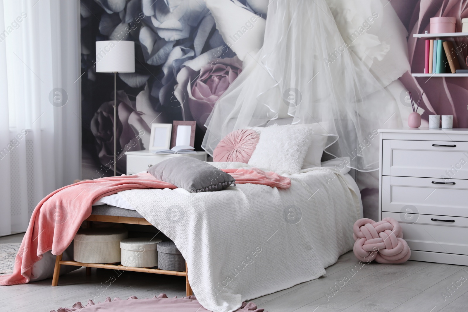 Photo of Teenage girl's room interior with comfortable bed and floral wallpaper. Idea for stylish design