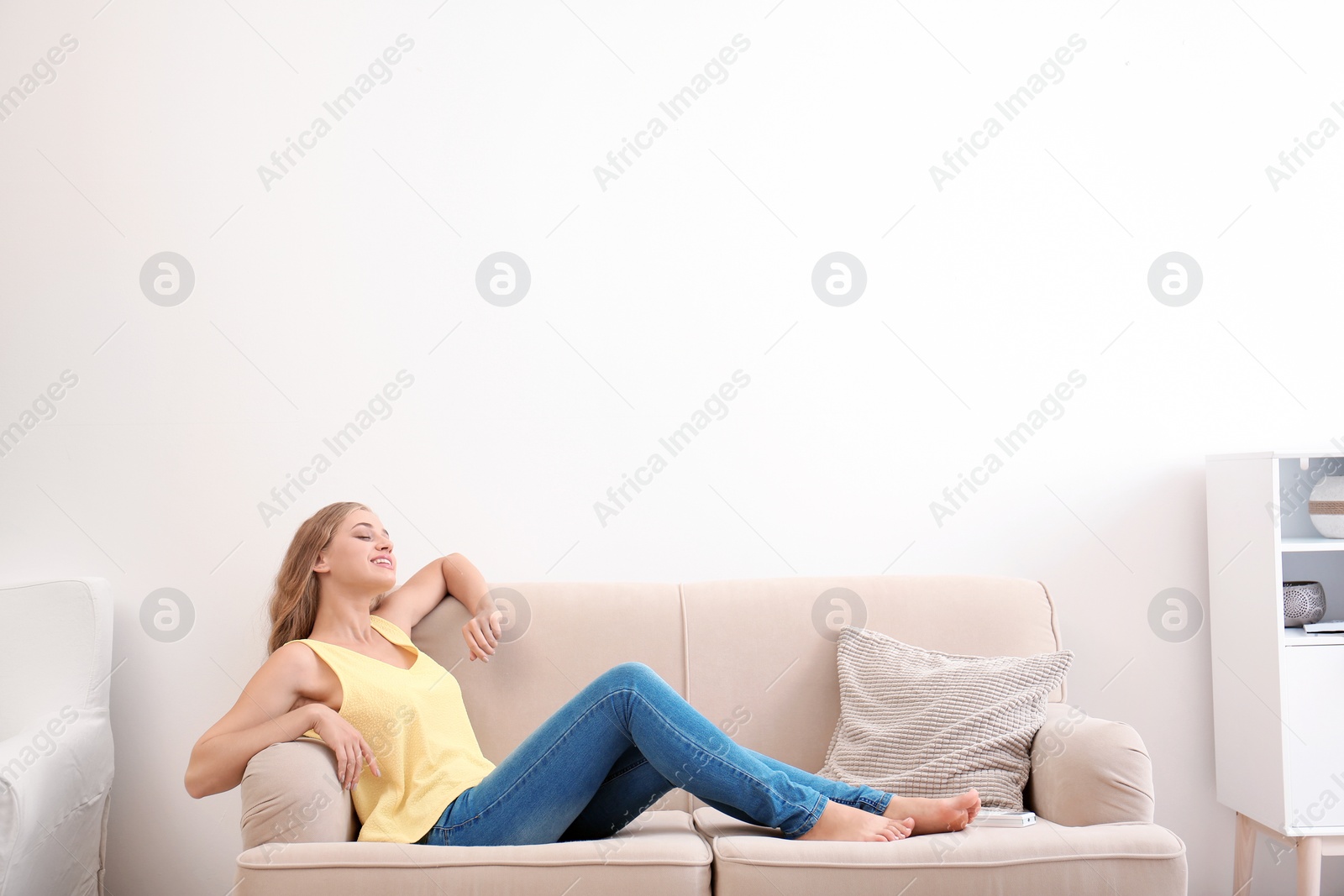 Photo of Young woman relaxing under air conditioner at home