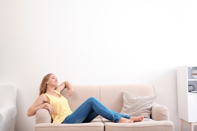 Young woman relaxing under air conditioner at home