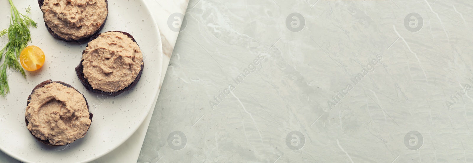 Image of Slices of bread with delicious pate served on white marble table, top view. Banner design with space for text