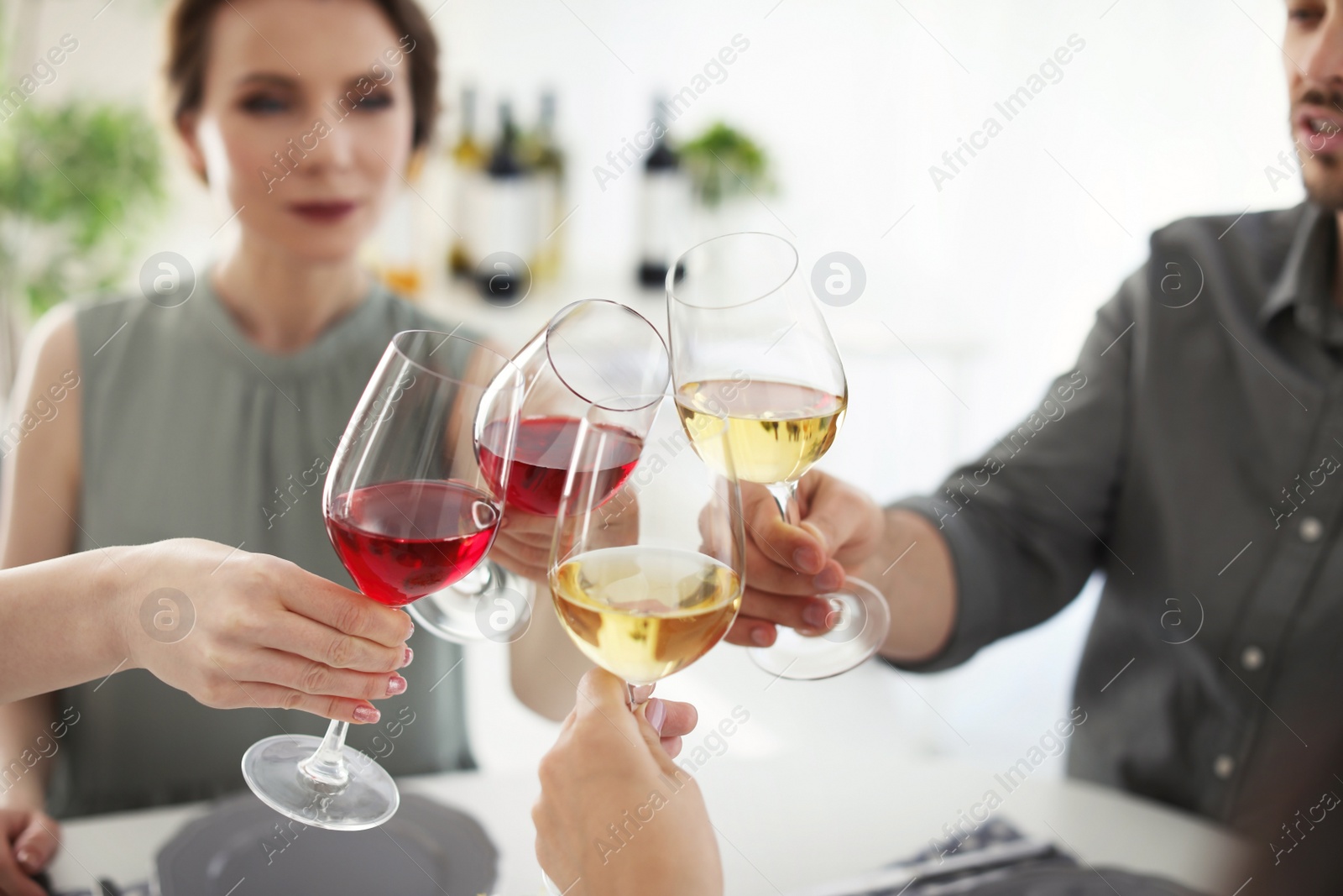 Photo of Young people with glasses of delicious wine at table