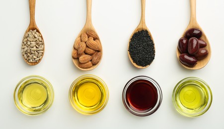 Photo of Vegetable fats. Different cooking oils in bowls and spoons with ingredients on white background, flat lay