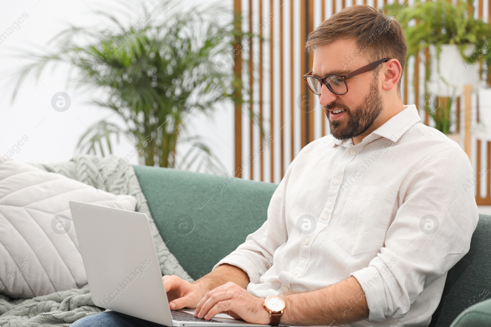 Photo of Young man working with laptop at home