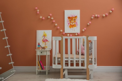 Photo of Cute pictures and crib in baby room interior