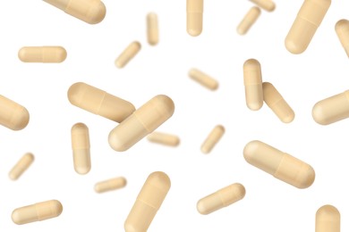 Image of Vitamin. Many capsules falling on white background