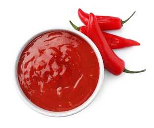 Photo of Bowl with red sauce and fresh chili peppers isolated on white, top view