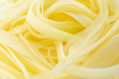 Raw white carrot noodles as background, closeup