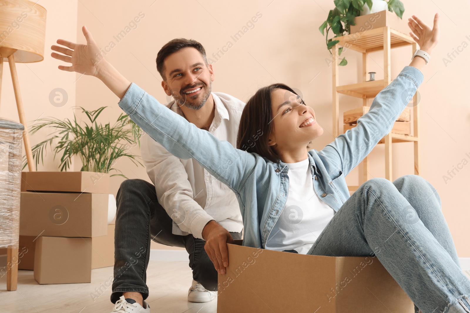 Photo of Happy couple having fun in new apartment. Moving day