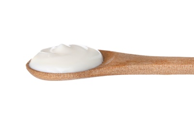 Photo of Wooden spoon with sour cream on white background