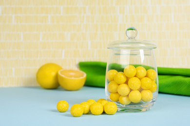 Delicious lemon drops on blue table. Space for text