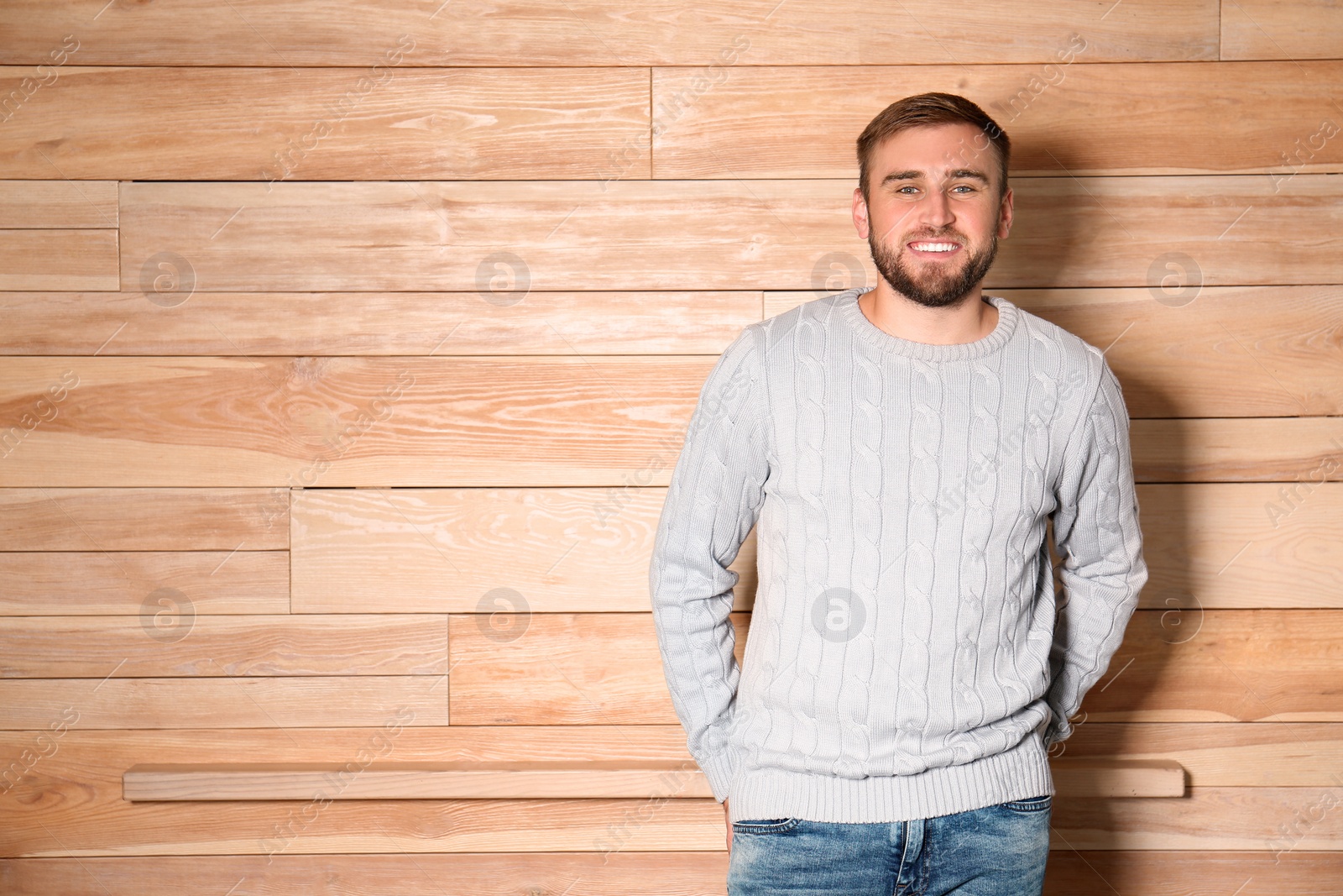 Image of Handsome man wearing warm sweater on wooden background. Space for text