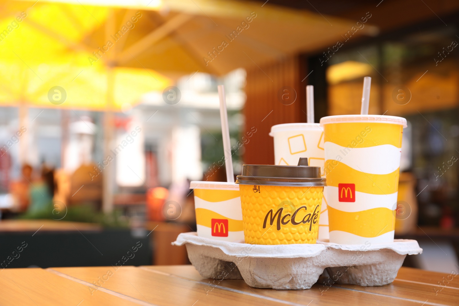 Photo of MYKOLAIV, UKRAINE - AUGUST 11, 2021: Cold and hot McDonald's drinks on table in cafe. Space for text