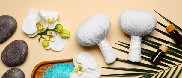 Image of Flat lay composition with herbal massage bags and other spa products on beige background, space for text. Banner design