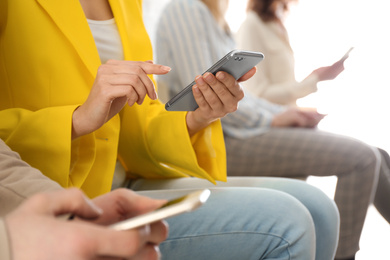 Photo of Young woman using modern smartphone indoors, closeup