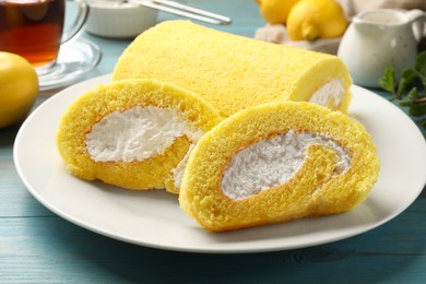 Photo of Delicious cake roll on light blue wooden table, closeup
