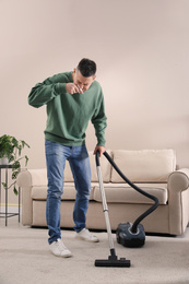 Man with dust allergy cleaning his home