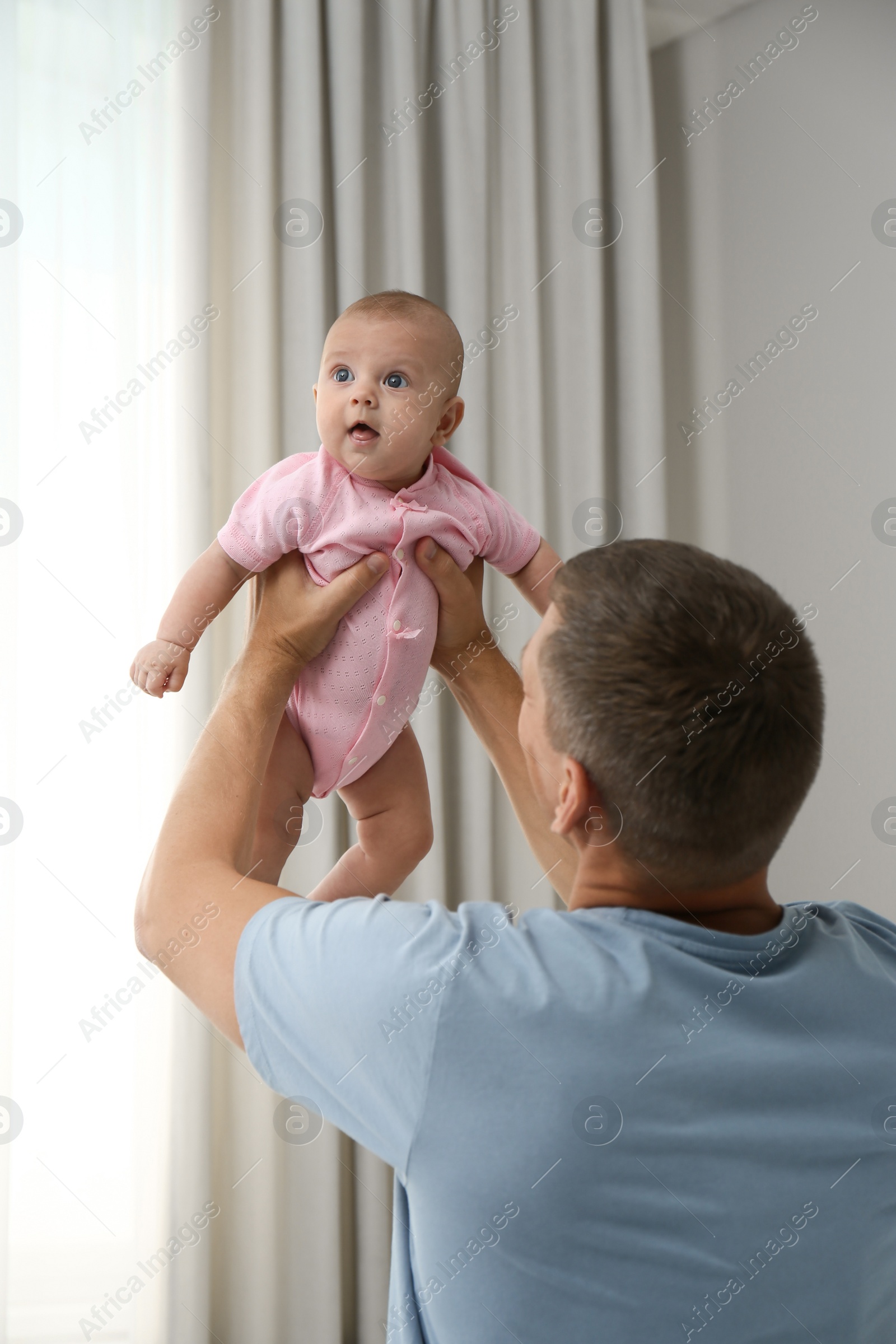 Photo of Father holding his cute baby at home