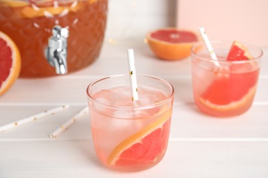 Photo of Delicious refreshing lemonade with grapefruit slices on white wooden table