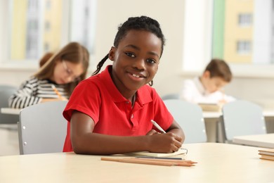 Photo of Portrait of smiling little boy studying in classroom at school