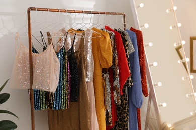 Rack with different stylish women's clothes indoors