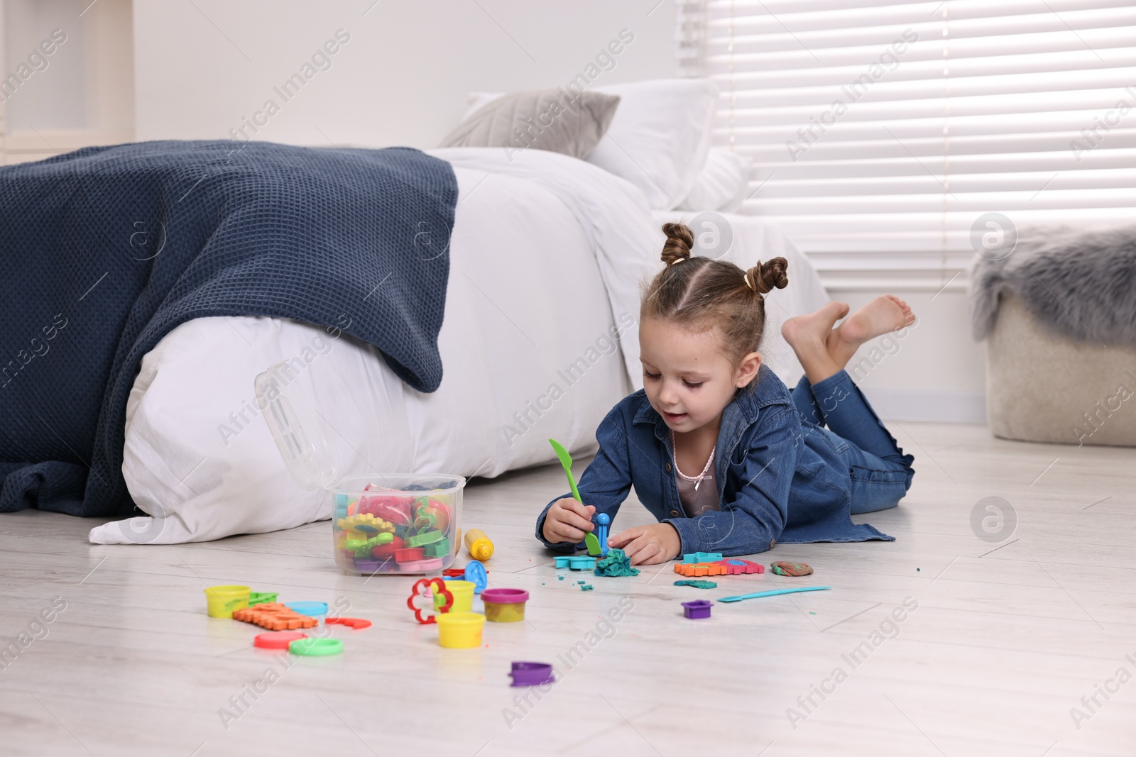 Photo of Cute little girl playing on warm floor at home. Heating system