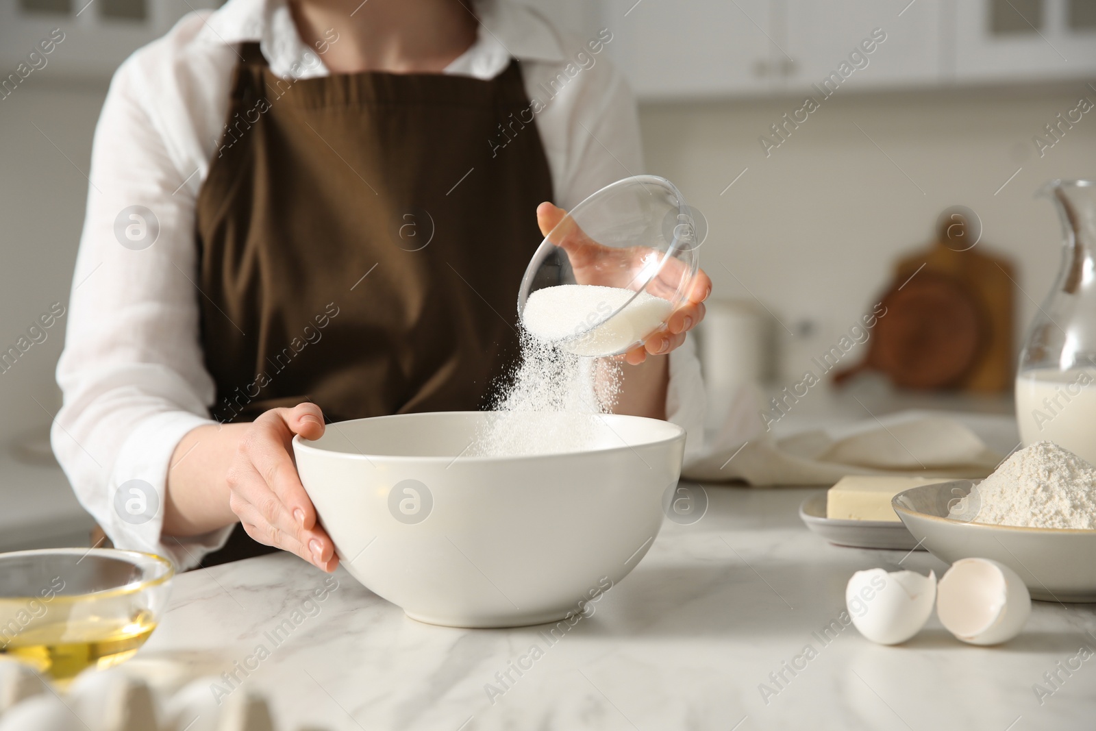 Photo of Woman making dough at table in kitchen, closeup