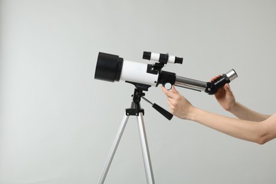 Photo of Astronomer with telescope on grey background, closeup