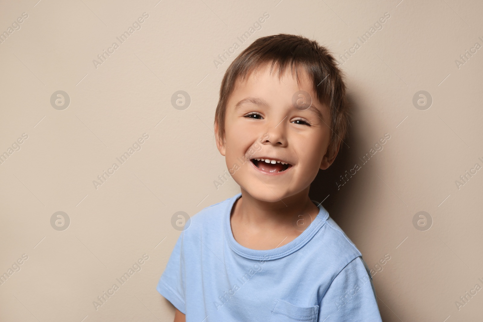 Photo of Portrait of cute little boy on beige background