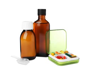 Photo of Bottles of syrups, plastic spoon with pills on white background. Cough and cold medicine