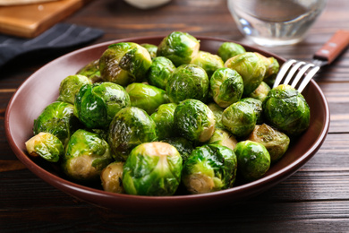 Photo of Delicious roasted Brussels sprouts on wooden table