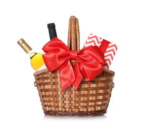 Photo of Festive basket with bottles of wine and gift on white background