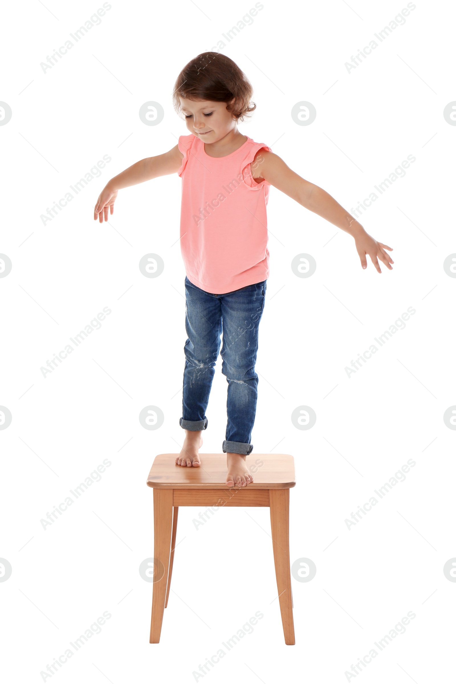 Photo of Little girl on stool against white background. Danger at home