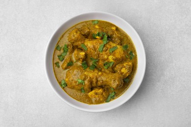 Photo of Delicious chicken with curry sauce on white table, top view