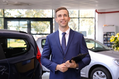 Photo of Portrait of young car salesman in dealership
