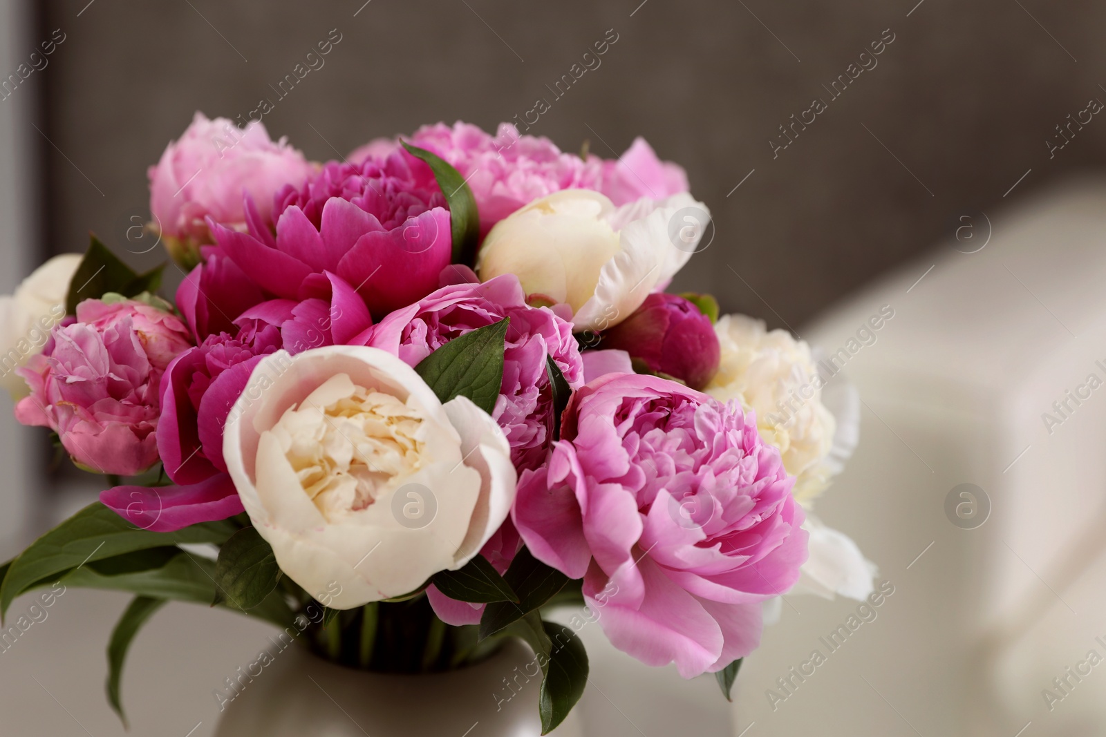 Photo of Vase with bouquet of beautiful peonies in room, closeup