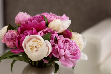 Photo of Vase with bouquet of beautiful peonies in room, closeup