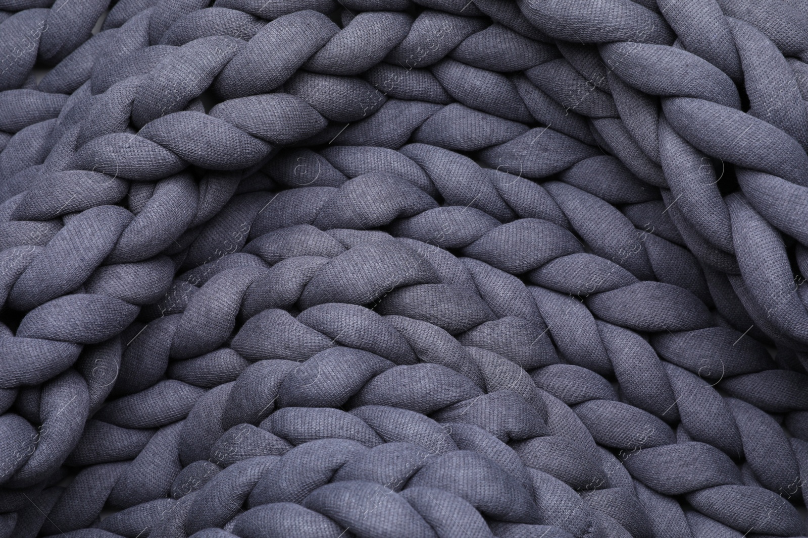 Photo of Top view of grey chunky knit blanket as background