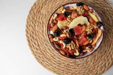 Bowl with mixed dried fruits and nuts on white table, top view. Space for text