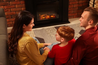 Happy family spending time together on floor near fireplace at home